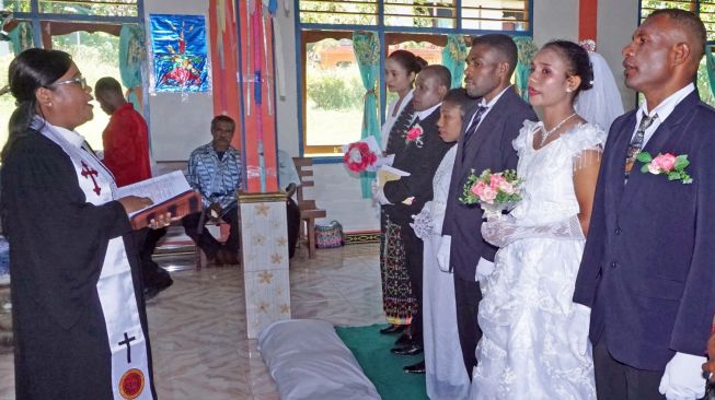 Pendeta Paulina mendoakan empat pasangan suami istri di Gereja Kristen Indonesia (GKI) Eden Tindaret, Yapen Utara, Kepulauan Yapen, Papua, Kamis (26/12). [ANTARA FOTO/Indrayadi TH]