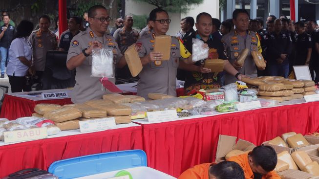 Kapolda Metro Jaya Komjen Pol Gatot Eddy Pramono (kedua kiri) menunjukkan barang bukti yang berhasil diamankan saat rilis akhir tahun di halaman gedung balai pertemuan Polda Metro Jaya, Jakarta, Jumat (27/12). [Suara.com/Angga Budhiyanto]