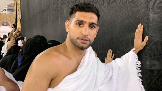 Petinju Muslim asal Inggris, Amir Khan, berada di dekat Ka'bah di dalam Masjidil Haram, saat melaksanakan ibadah umrah di Mekkah, Arab Saudi. [Twitter/amirkingkhan]