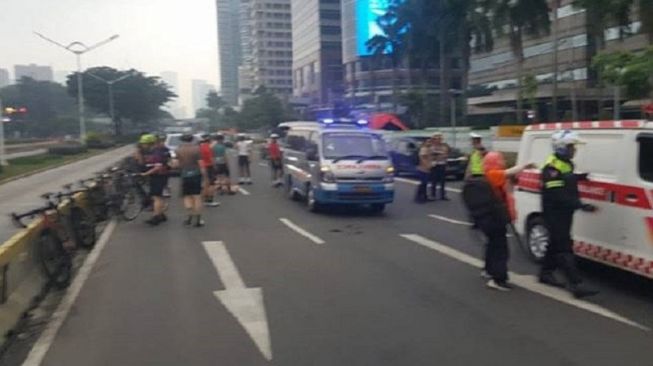 Petugas kepolisian mengamankan Tempat Kejadian Perkara kecelakaan minibus yang mengakibatkan tujuh pesepeda terluka di Jalan Jendral Sudirman Jakarta Selatan, Sabtu (28/12/2019). [Polda Metro Jaya]