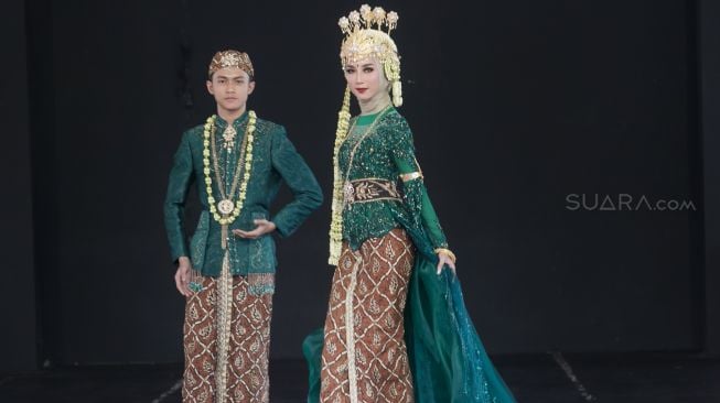 Model dengan busana pengantin dari daerah Bandung di Panggung Kesenian anjungan Jawa Barat, Taman Mini Indonesia Indah, Jakarta Timur (29/12). [Suara.com/Alfian Winanto]