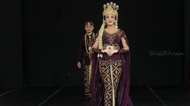 Model dengan busana pengantin dari daerah Bandung Barat di Panggung Kesenian anjungan Jawa Barat, Taman Mini, Jakarta, Minggu (29/12). [Suara.com/Alfian Winanto]