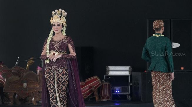 Model dengan busana pengantin dari daerah Bandung Barat di Panggung Kesenian anjungan Jawa Barat, Taman Mini, Jakarta, Minggu (29/12). [Suara.com/Alfian Winanto]