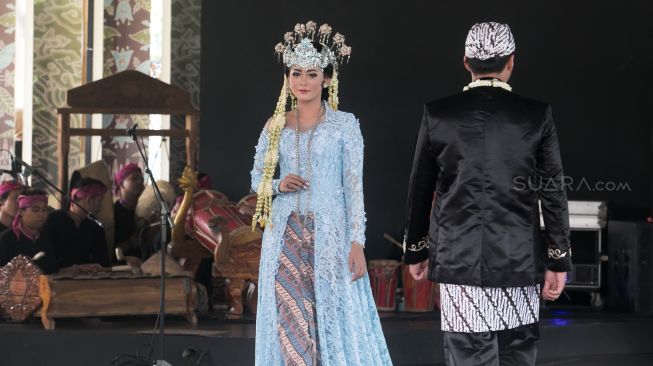 Model yang berjalan di catwalk dalam pagelaran pesona Budaya Jawa Barat, di Panggung Kesenian anjungan Jawa Barat, Taman Mini Indonesia Indah, Jakarta Timur (29/12). [Suara.com/Alfian Winanto]