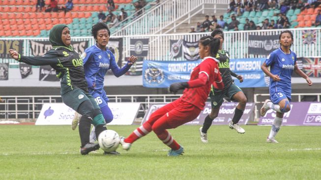 Pesepak bola Tira Persikabo Kartini Insyafada (kiri) berusaha menendang bola yang dihadang kiper Persib Bandung Putri Vivi Oktavia (kanan) dalam babak final leg ke-2 Liga 1 Putri 2019 di Stadion Pakansari, Cibinong, Bogor, Jawa Barat, Sabtu (28/12). [ANTARA FOTO/Yulius Satria Wijaya]