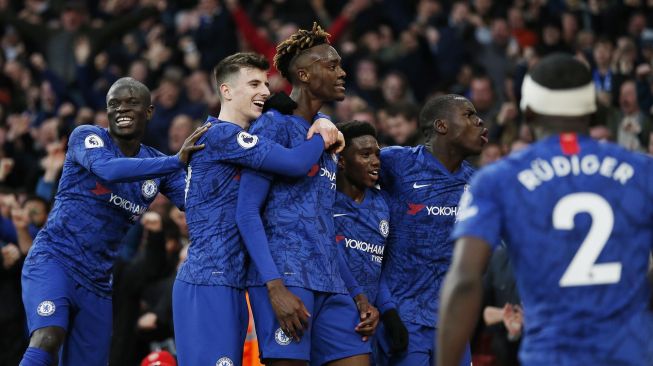 Striker Chelsea Tammy Abraham merayakan golnya bersama rekan-rekanya usai mencetak gol kedua mereka untuk memimpin 1-2 selama pertandingan sepak bola Liga Inggris antara Arsenal melawan Chelsea di Stadion Emirates, London, Inggris, Minggu (29/12). [Ian KINGTON / IKIMAGES / AFP]