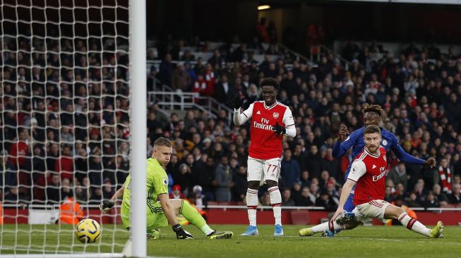 Striker Chelsea Tammy Abraham mencetak gol kedua mereka untuk memimpin 1-2 selama pertandingan sepak bola Liga Inggris antara Arsenal melawan Chelsea di Stadion Emirates, London, Inggris, Minggu (29/12). [Ian KINGTON / IKIMAGES / AFP]