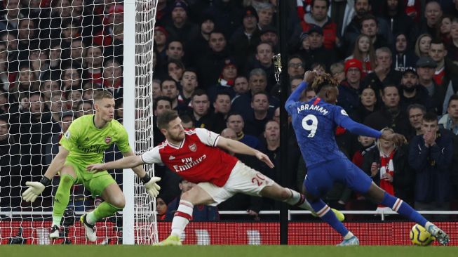 Striker Chelsea Tammy Abraham (kanan) mencetak gol kedua mereka untuk memimpin 1-2 selama pertandingan sepak bola Liga Inggris antara Arsenal melawan Chelsea di Stadion Emirates, London, Inggris, Minggu (29/12). [Adrian DENNIS / AFP]