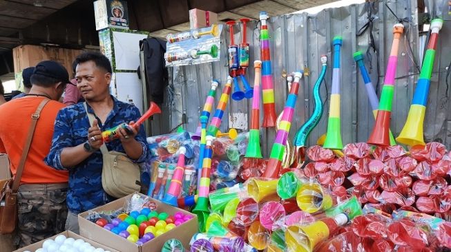 Pedagang terompet tahun baru di Pasar Asemka, Jakarta Pusat. (Suara.com/Risna Halidi)