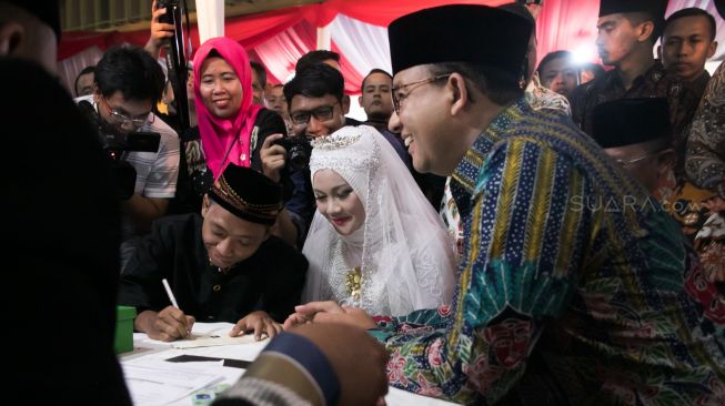 Prosesi simbolik nikah massal yang dipimpin langsung oleh Gubernur DKI Jakarta Anies Baswedan di acara nikah massal yang ada di Balaikota, Gambir, Jakarta Pusat, Selasa (31/12). [Suara.com/Alfian Winanto]