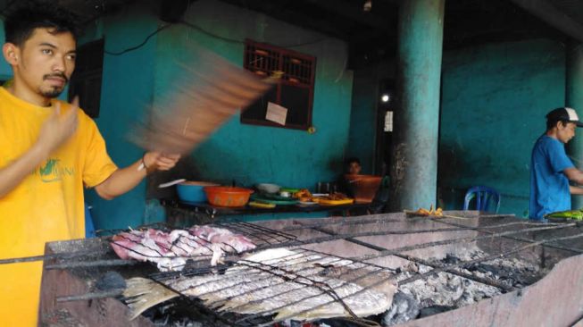 Pengelola Rumah Makan Lancar di Jalan Raya Caringin Kecamatan Labuan, Akew. [Suara.com/Saepulloh]