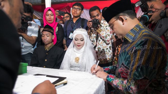 Prosesi simbolik nikah massal yang dipimpin langsung oleh Gubernur DKI Jakarta Anies Baswedan di acara nikah massal yang ada di Balaikota, Gambir, Jakarta Pusat, Selasa (31/12). [Suara.com/Alfian Winanto]