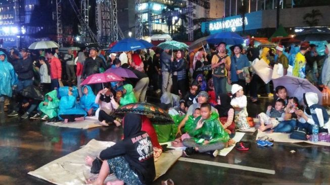 Bermandi Hujan, Warga Jakarta Nikmati Hiburan Malam Tahun Baru