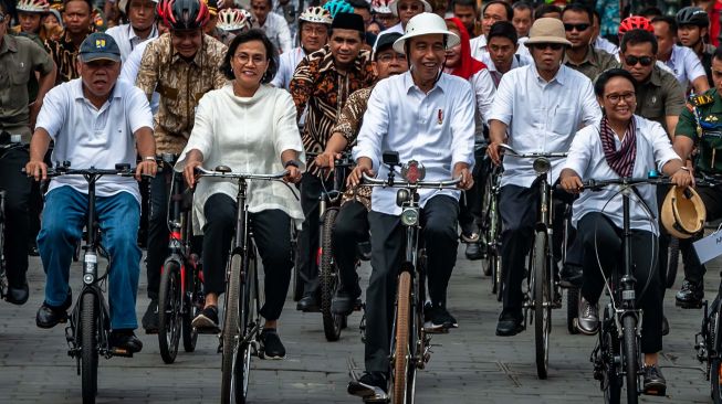 Presiden Joko Widodo (tengah) didampingi Menteri Luar Negeri Retno Marsudi (kanan), Menteri Keuangan Sri Mulyani (kedua kiri), Menteri PUPR Basuki Hadimuldjono (kiri) naik sepeda ontel di Kawasan Kota Lama Semarang, Jawa Tengah, Senin (30/12). [ANTARA FOTO/Aji Styawan]