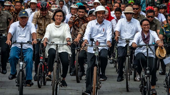 Presiden Joko Widodo (tengah) didampingi Menteri Luar Negeri Retno Marsudi (kanan), Menteri Keuangan Sri Mulyani (kedua kiri), Menteri PUPR Basuki Hadimuldjono (kiri) naik sepeda ontel di Kawasan Kota Lama Semarang, Jawa Tengah, Senin (30/12). [ANTARA FOTO/Aji Styawan]