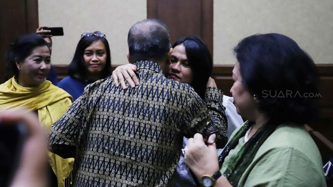 Mantan Dirut Utama PT Garuda Indonesia (persero) Tbk, Emirsyah Satar, memeluk keluarga usai menjalani sidang perdana dengan agenda pembacaan dakwaan di Pengadilan Tipikor, Jakarta Pusat, Jakarta, Senin (30/12).  [Suara.com/Alfian Winanto]