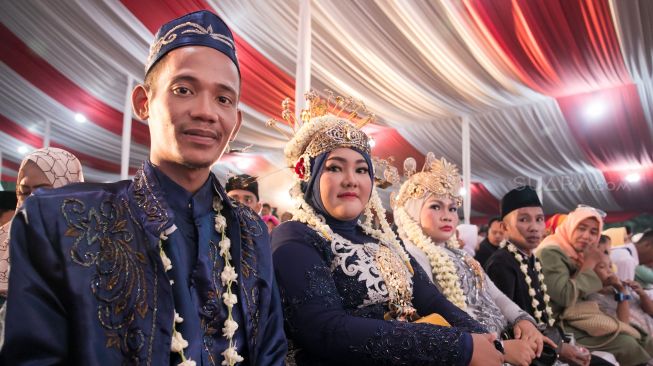 Para pasangan yang menghadiri acara nikah massal yang ada di Balaikota, Gambir, Jakarta Pusat, Selasa (31/12). [Suara.com/Alfian Winanto]