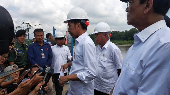 Presiden Joko Widodo (Jokowi) memberi keterangan kepada wartawan usai meresmikan Bendung Kamijoro di Kulon Progo, Selasa (31/12/2019). - (SUARA/Baktora)