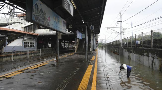 Petugas memeriksa rel kereta api yang terendam banjir di Stasiun KA Tanah Abang, Jakarta, Rabu (1/1). [ANTARA FOTO/Nova Wahyudi]

