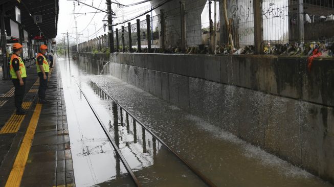 Petugas memeriksa rel kereta api yang terendam banjir di Stasiun KA Tanah Abang, Jakarta, Rabu (1/1). [ANTARA FOTO/Nova Wahyudi]

