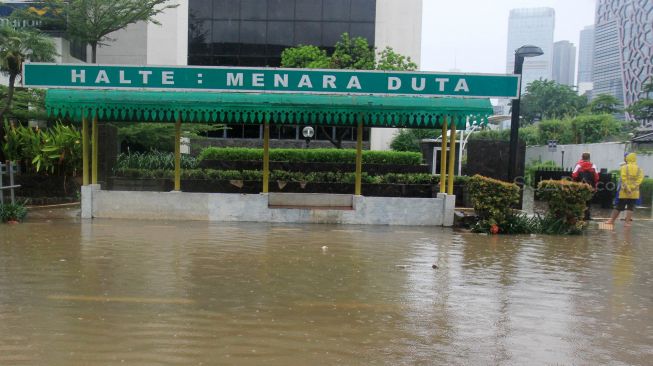 Halte bus terendam banjir di jalan HR Rasuna Said, Jakarta Selatan, Rabu (1/1). [Suara.com/Oke Atmaja]
