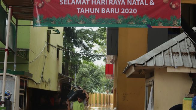 Pedagang menyelamatkan barang dagangannya dari banjir yang merendam Pasar Cipulir, Jakarta Selatan, Rabu (1/1). [Suara.com/Angga Budhiyanto]