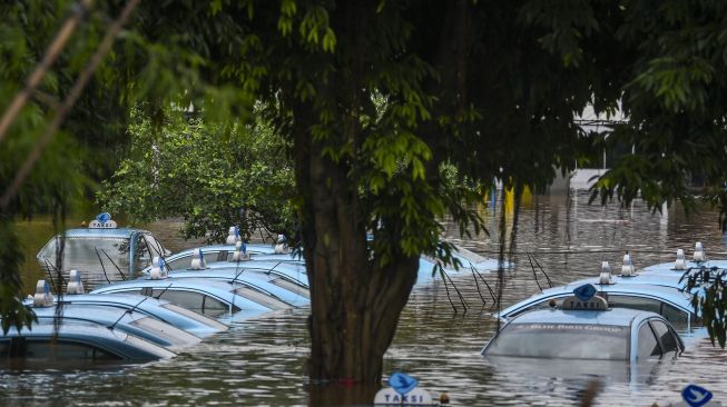 Suasana mobil taksi yang terendam di pool taksi Kramat Jati, Jalan Raya Pondok Gede, Jakarta, Rabu (1/1).[ANTARA FOTO/Galih Pradipta]