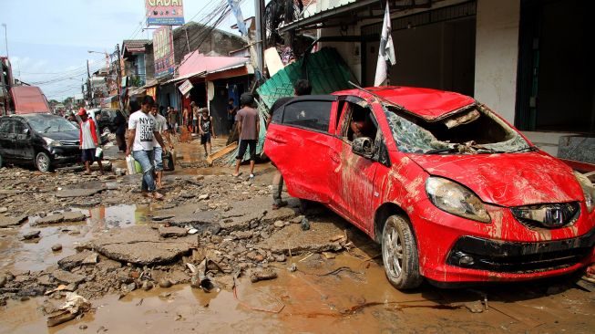 Sejumlah kendaraan dan akses jalan hancur pasca banjir yang merendam kawasan Pondok Gede Permai, Jatiasih, Bekasi, Jawa Barat, Kamis (2/1). [ANTARA FOTO/Risky Andrianto]