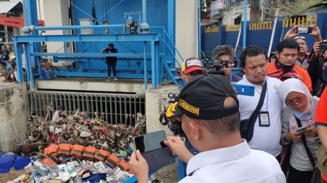 Tinjau Pintu Air Manggarai, Menko PMK Abadikan Sampah-Sampah Melalui Ponsel