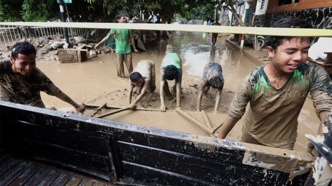 Warga membersihkan endapan lumpur di Perumahan Pondok Mitra Lestari, Bekasi, Jawa Barat, Jumat (3/1). [Suara.com/Angga Budhiyanto]