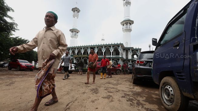 Warga bergegas pulang usai menunaikan ibadah salat Jumat di Masjid Siti Rawani, Jatiasih, Bekasi, Jawa Barat, Jumat (3/1). [Suara.com/Angga Budhiyanto]