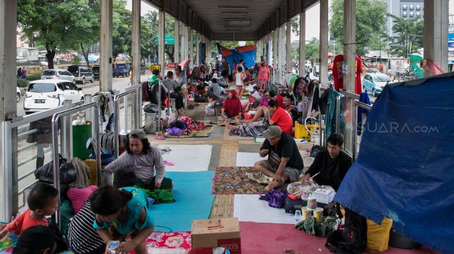 Warga mengungsi di Halte Transjakarta Jembatan Baru, Daan Mogot, Jakarta Barat, Jumat (03/01). [Suara.com/Alfian Winanto]