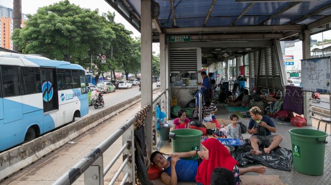 Warga mengungsi di Halte Transjakarta Jembatan Baru, Daan Mogot, Jakarta Barat, Jumat (03/01). [Suara.com/Alfian Winanto]