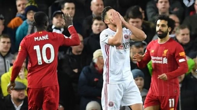 Pemain Liverpool Mohamed Salah (kanan) merayakan golnya ke gawang Sheffield United dengan rekan setimnya, Sadio Mane dalam laga Liga Inggris di Anfield. Paul ELLIS / AFP