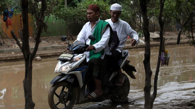 Warga berjalan menuju Masjid Siti Rawani, Jatiasih, Bekasi, Jawa Barat, Jumat (3/1). [Suara.com/Angga Budhiyanto]