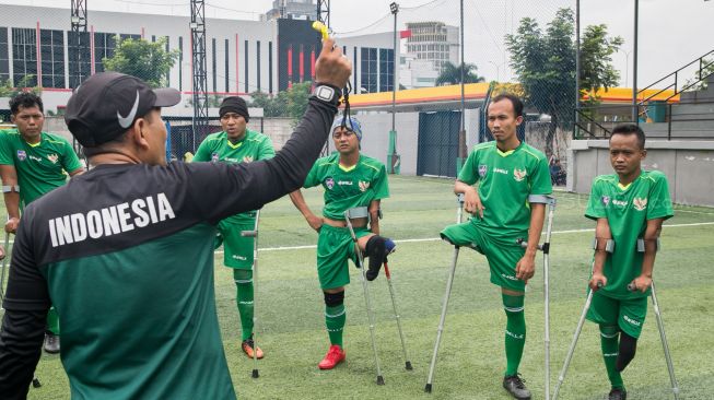 Pelatih Tim sepak bola Garuda INAF yang beranggotakan penyandang disabilitas memberikan arahan saat berlatih di lapangan baru di Cilandak,  Jakarta Selatan, Sabtu (04/01).  [Suara.com/Alfian Winanto]