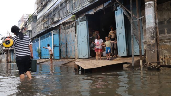 Suasana dan aktivitas warga kawasan Teluk Gong di Penjaringan, Jakarta Utara, yang masih terendam banjir pada Sabtu (4/1/2020). [Suara.com / Alfian Winanto]