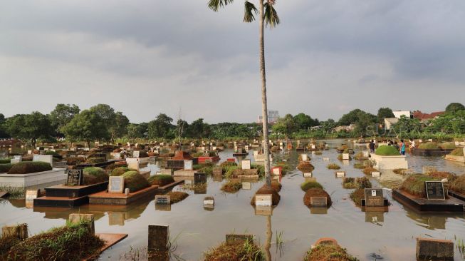 Makam yang terendam banjir di komplek makam TPU Tanah Kusir, Kebayoran Lama, Jakarta Selatan, Jumat (03/01). [Suara.com/Alfian Winanto]
