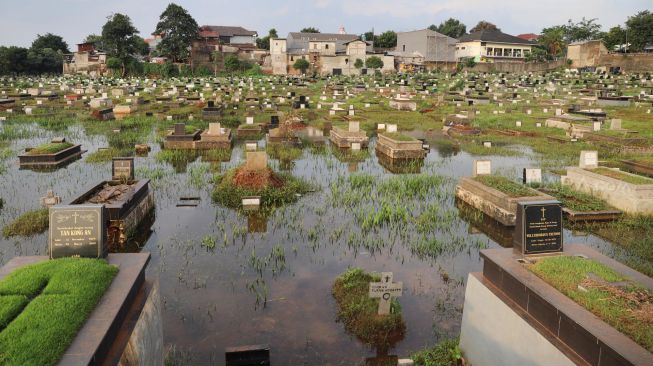 Makam yang terendam banjir di komplek makam TPU Tanah Kusir, Kebayoran Lama, Jakarta Selatan, Jumat (03/01). [Suara.com/Alfian Winanto]
