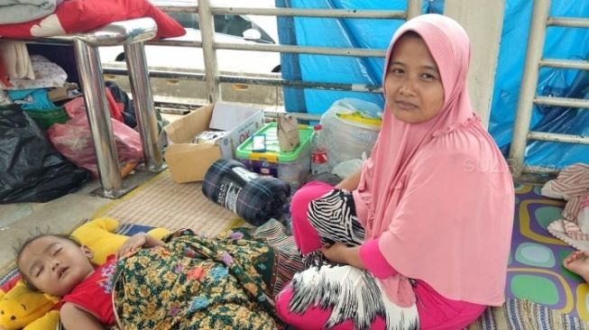 Penampakan korban banjir di Rawa Buaya yang mengungsi di Halte TransJakarta Jembatan Baru. (Suara.com/Fakhri).