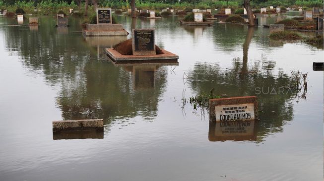 Makam yang terendam banjir di komplek makam TPU Tanah Kusir, Kebayoran Lama, Jakarta Selatan, Jumat (03/01). [Suara.com/Alfian Winanto]
