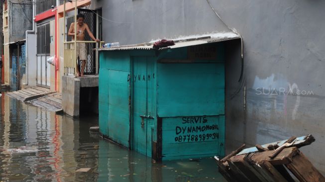 Suasana dan aktivitas warga Teluk Gong di Penjaringan, Jakarta Utara, yang masih terendam banjir pada Sabtu (4/1/2020). [Suara.com / Alfian Winanto]