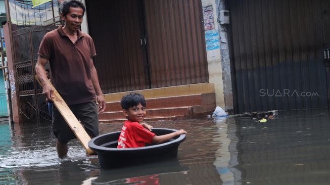 Aktivitas warga di kawasan Teluk Gong di Penjaringan, Jakarta Utara, yang masih terendam banjir pada Sabtu (4/1/2020). [Suara.com / Alfian Winanto]