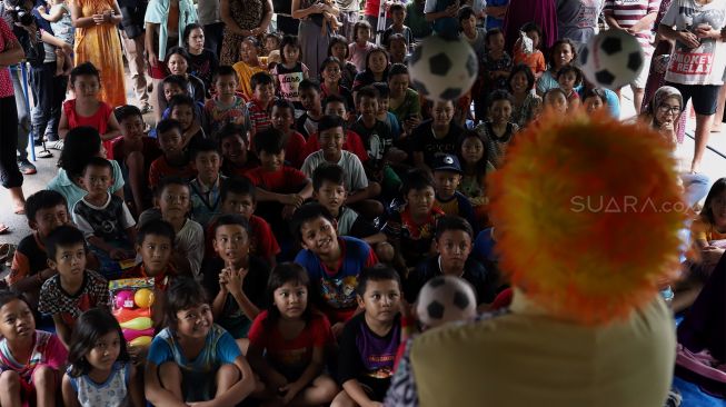 Badut yang tergabung dalam komunitas Aku Badut Indonesia (ABI) menghibur anak-anak di pengungsian korban banjir Komplek IKPN Bintaro, Pesanggrahan, Jakarta Selatan, Minggu (5/1). [Suara.com/Angga Budhiyanto]