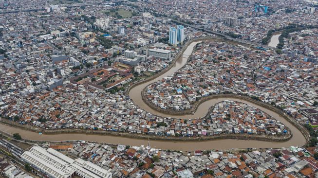 Foto udara suasana wilayah bantaran sungai Ciliwung di kawasan Bukit Duri, Jakarta, Minggu (5/1). [ANTARA FOTO/Muhammad Adimaja]