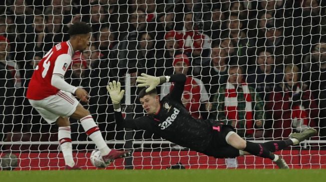 Winger muda Arsenal, Reiss Nelson (kiri) melepaskan sepakan ke gawang lawan pada laga Piala FA 2019/2020 kontra Leeds United di Emirates Stadium, London, Selasa (7/1/2020 dini hari WIB). [Adrian DENNIS / AFP]