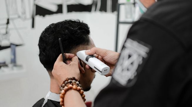 Ilustrasi pria cukur rambut di barbershop. (Unsplash/Firza Pratama)