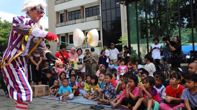 Sejumlah badut menghibur anak-anak korban banjir di posko pengungsian bencana banjir Gor  Pengadegan, Jakarta Selatan, Selasa (07/01). [Suara.com/Alfian Winanto]