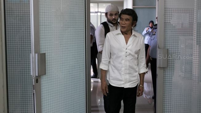 Aktor sekalgius penyanyi Ridho Rhoma didampingi ayahnya Rhoma Irama ketika keluar dari Rutan Salemba, Jakarta Pusat, Rabu (08/01). [Suara.com/Alfian Winanto]
