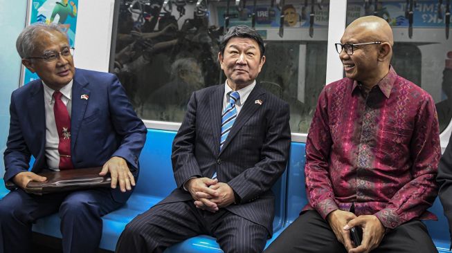 Menteri Luar Negeri Jepang Toshimitsu Motegi (tengah) berbincang bersama Direktur Utama PT MRT Jakarta William P Sabandar (kanan) dan Duta Besar Jepang untuk RI Masafumi Ishii (kiri) saat menumpang kereta MRT di Jakarta, Jumat (10/1). [ANTARA FOTO/Muhammad Adimaja]
